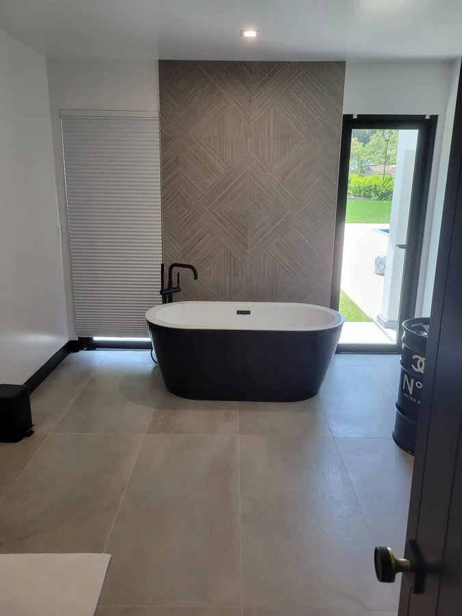 Black Soaking Tub &mdash; Herringbone flooring and a glass door to the yard.