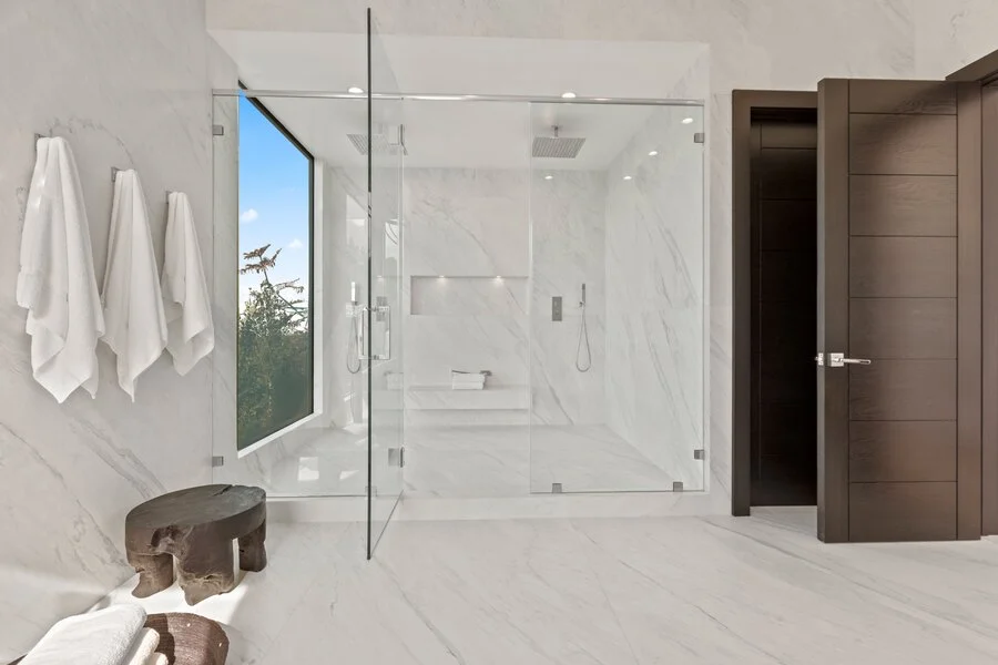 Glass & Marble &mdash; A glass-enclosed shower set in book-matched marble.