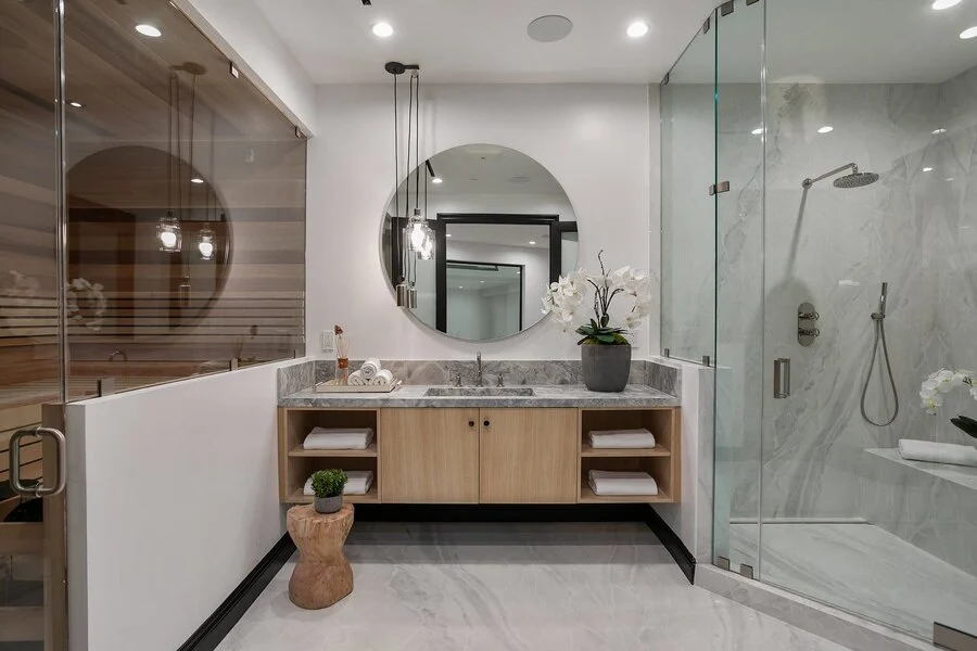 Double Vanity &mdash; Round mirrors over a floating stone-top vanity.