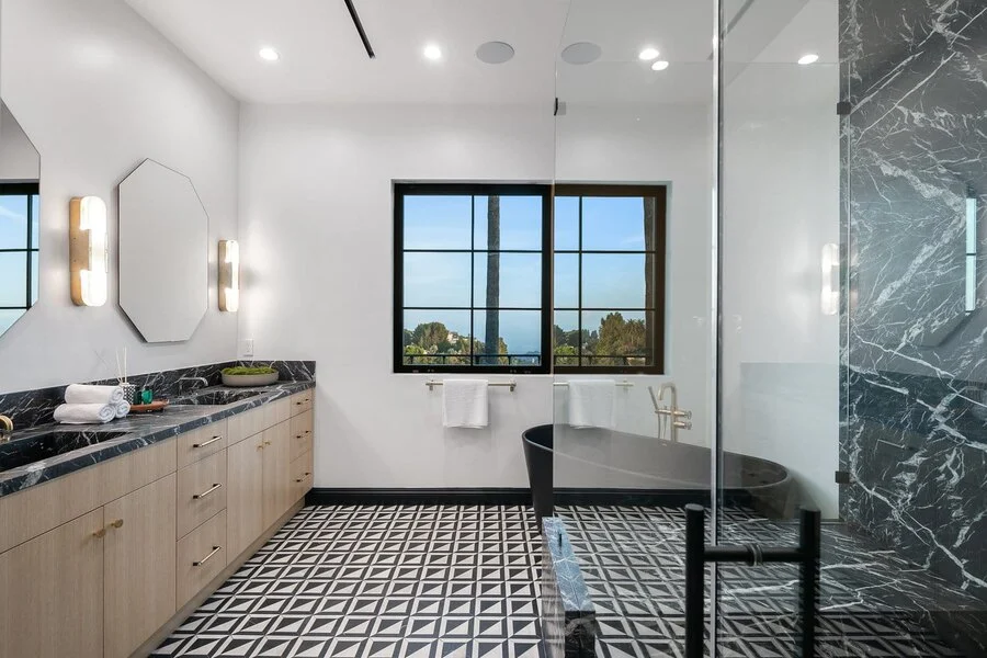 Dark Marble Vanity &mdash; Patterned tile and a window over the counter.