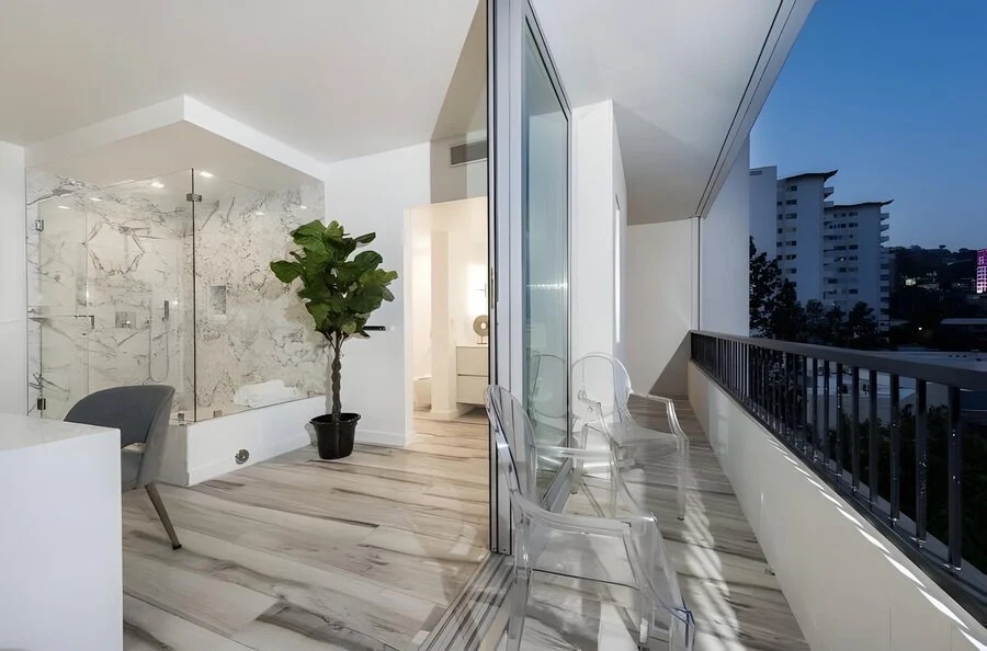 Balcony Bath &mdash; A glass shower beside an open-air skyline view.