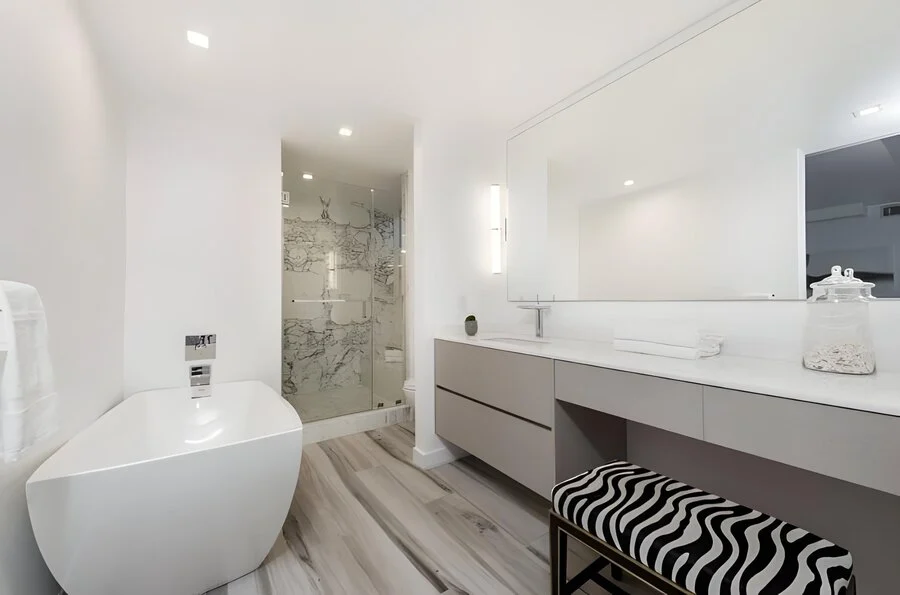 Soaking Tub &mdash; A sculptural white tub beside a striped bench.