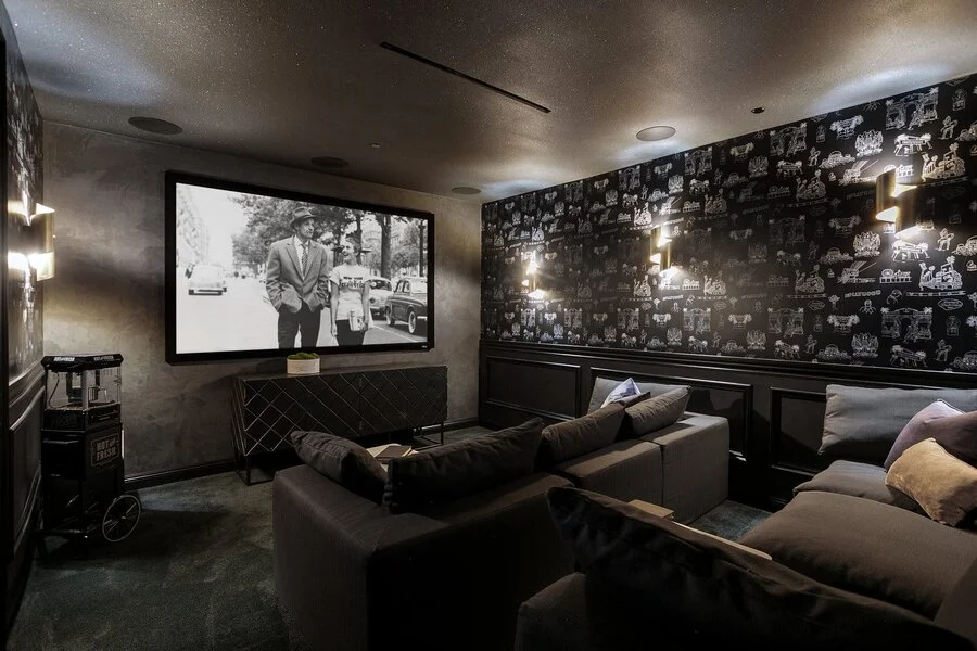 Home Theater &mdash; Tufted seating beneath a gallery of framed art.
