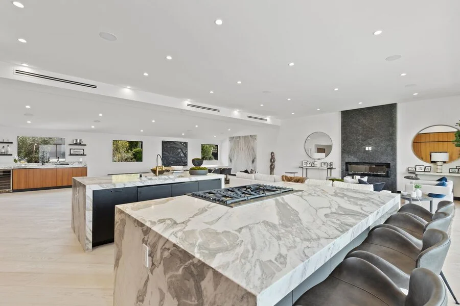 Waterfall Island &mdash; A full-slab marble island under linear pendants.
