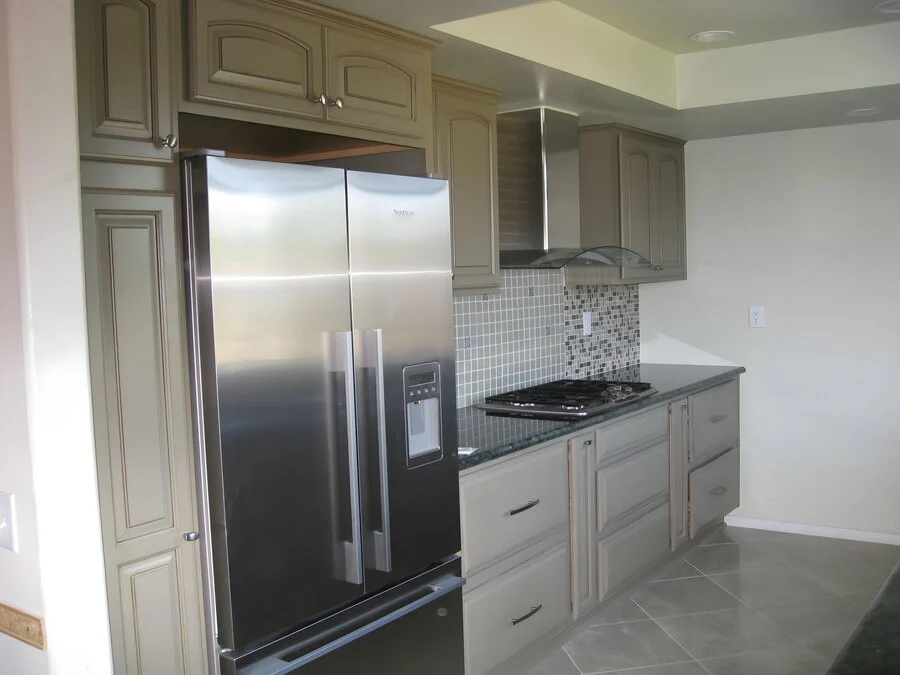 Farmhouse Kitchen &mdash; A paneled refrigerator and tile backsplash.