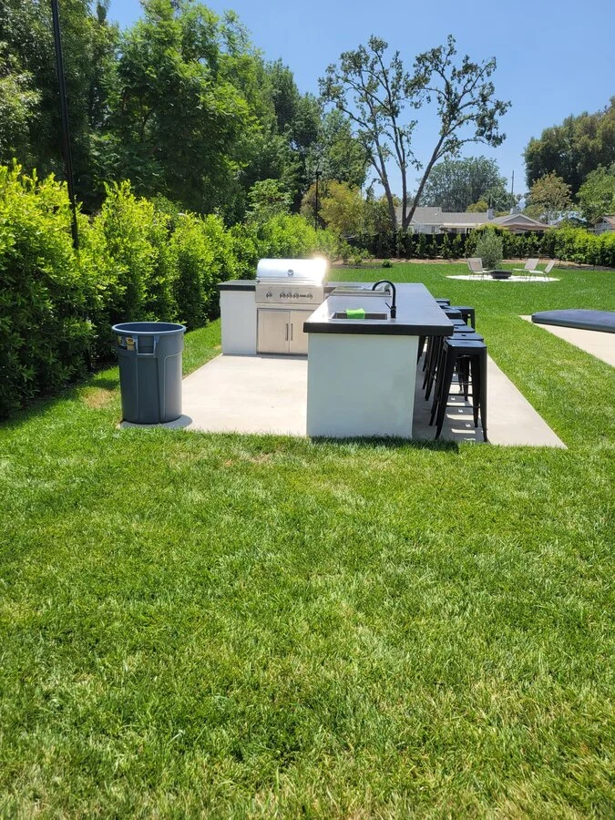Outdoor Kitchen &mdash; A built-in grill and bar, set into the lawn.