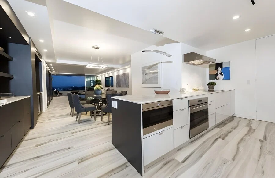 Open Kitchen &mdash; Waterfall island opening onto the dining room and skyline beyond.